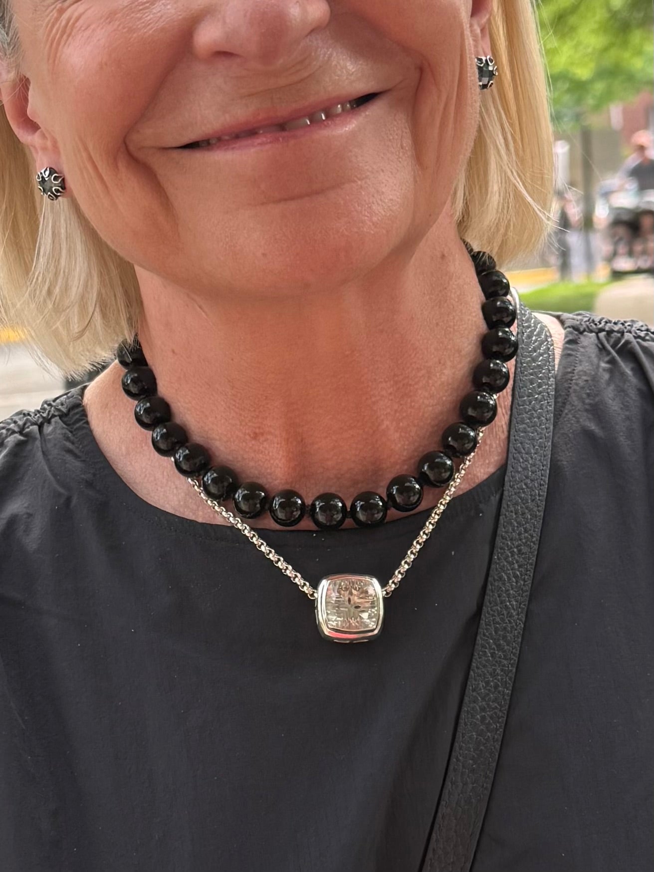 customer wearing Hannah Daye white quartz Concord Cusion pendant along with Poppy Hematite Earrings