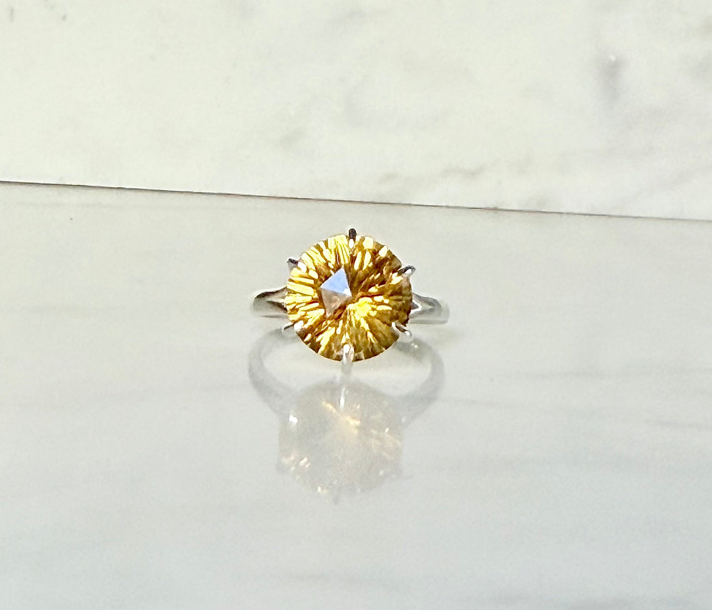 Citrine front view Sterling silver ring by Hannah Daye on smooth stone surface