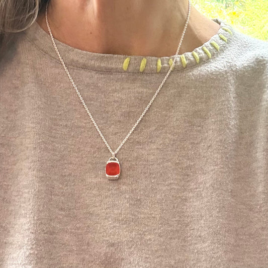 someone wearing red charm pendant