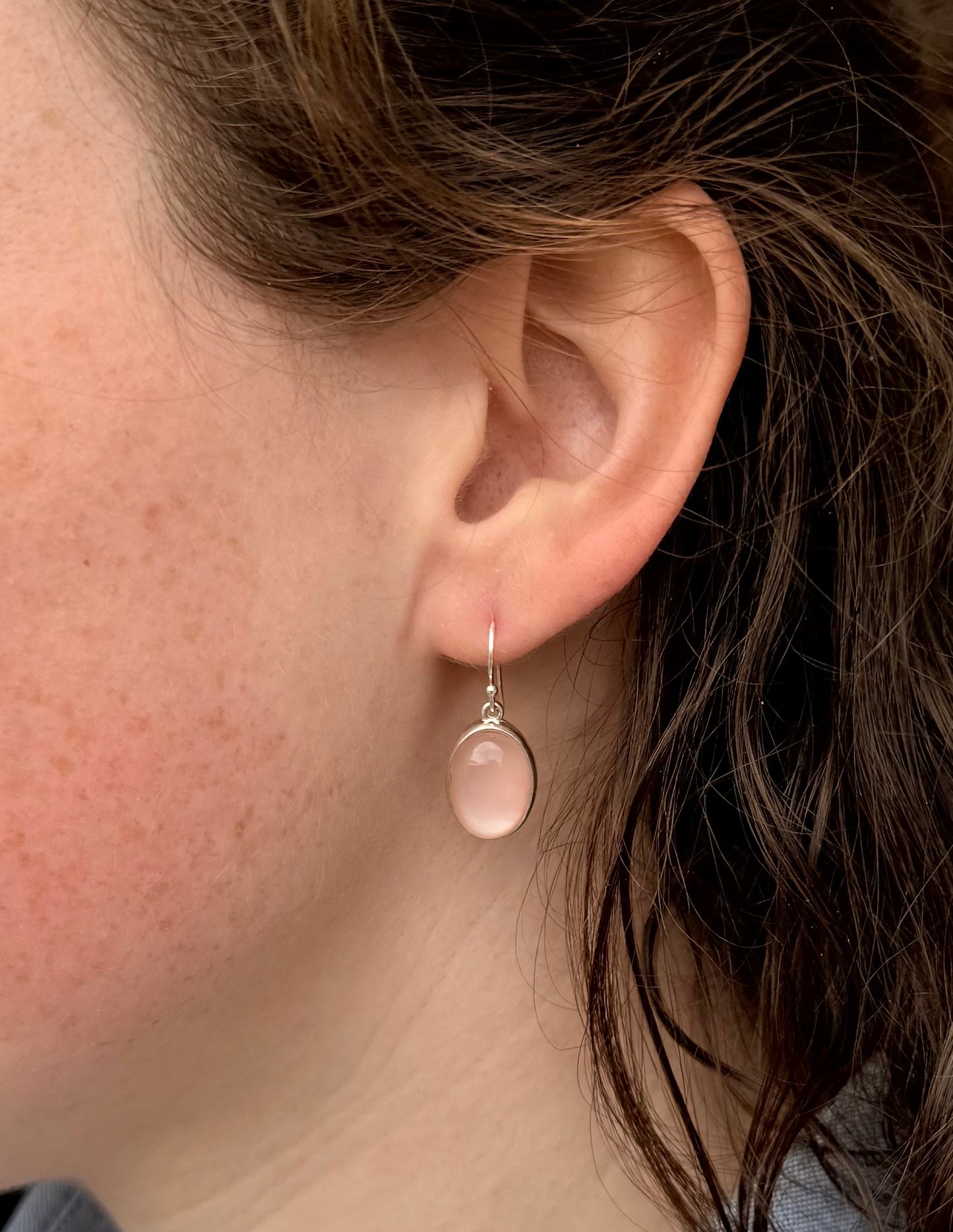 Close-up of an ear wearing a rose quartz earring