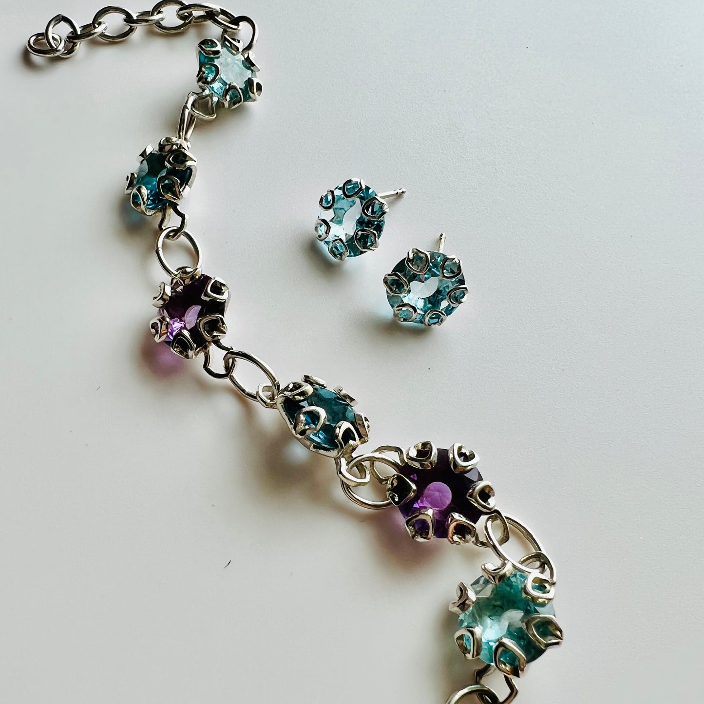 Poppy Earrings in Sky Blue Topaz shown with Poppy Bracelet in Amethyst and Blue Topaz all by Hannah Daye & Co