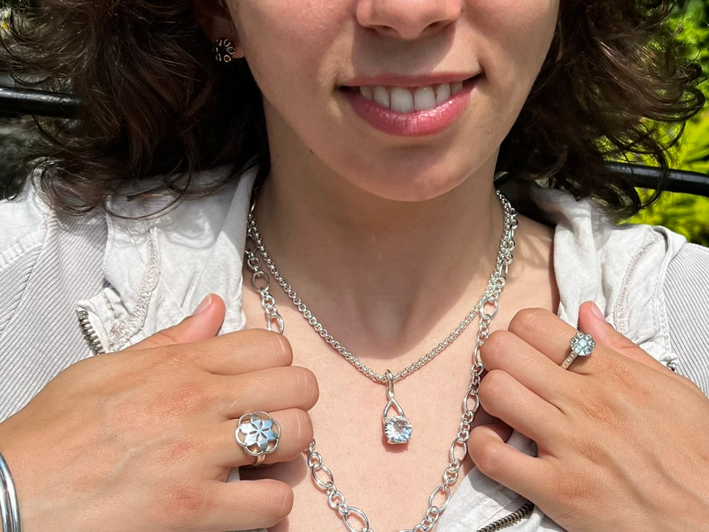 wearing Brillante White Quartz Pendant with Rosette Ring Poppy Ring all by Hannah Daye & Co