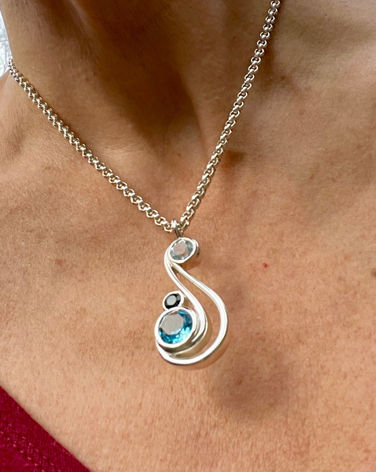 wearing Aria Pendant in Sky London and Swiss Blue Topaz by Hannah Daye fine jewelry designs