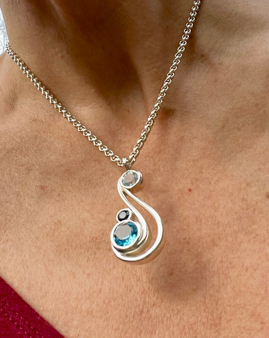 wearing Aria Pendant in Sky London and Swiss Blue Topaz by Hannah Daye fine jewelry designs