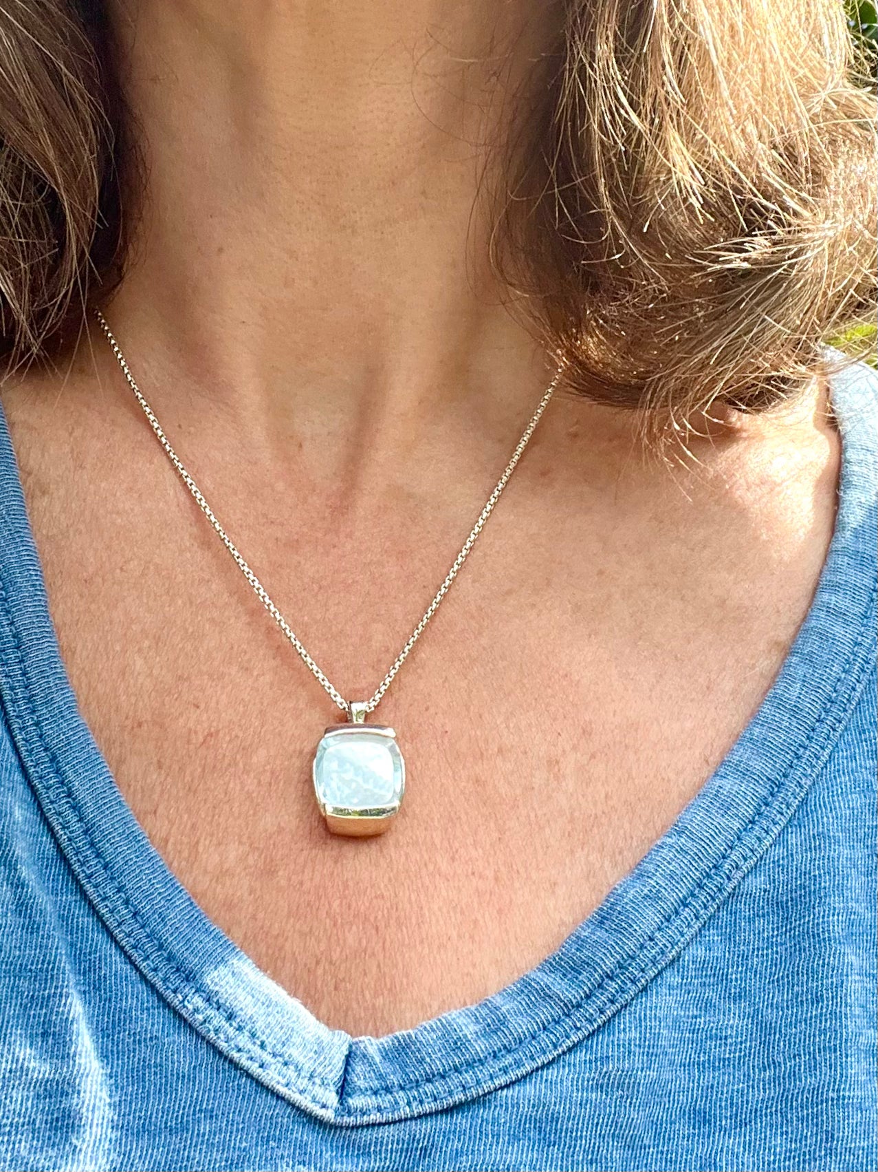 wearing Milan pendant sky blue topaz and mother of pearl 18" chain sterling silver by Hannah Daye fine jewelry