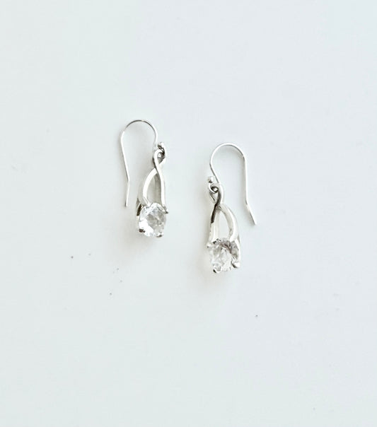 Pair of silver earrings with clear stones on a white background