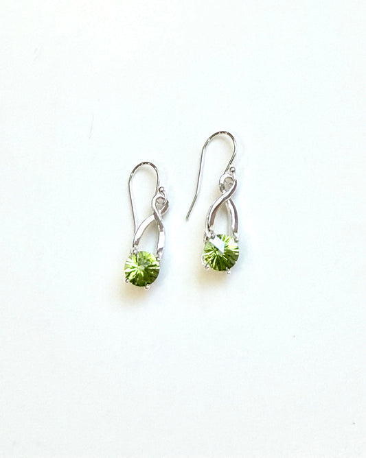 A pair of silver drop earrings with bright green faceted gemstones shown on a plain white background.