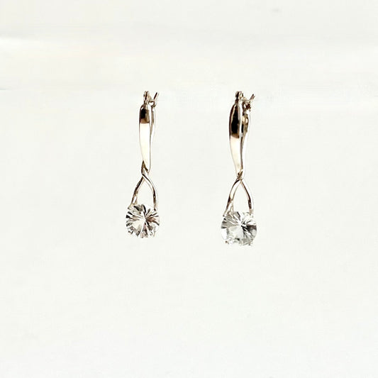 A pair of silver earrings with clear faceted round gemstones, displayed against a plain white background.