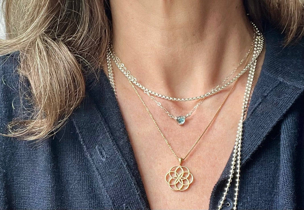 layering Fiore Rosette Pendant in 14k gold with Fiore Sterlign Necklace Swiss Blue Topaz and Bead Chain Necklace all by Hannah Daye & Co