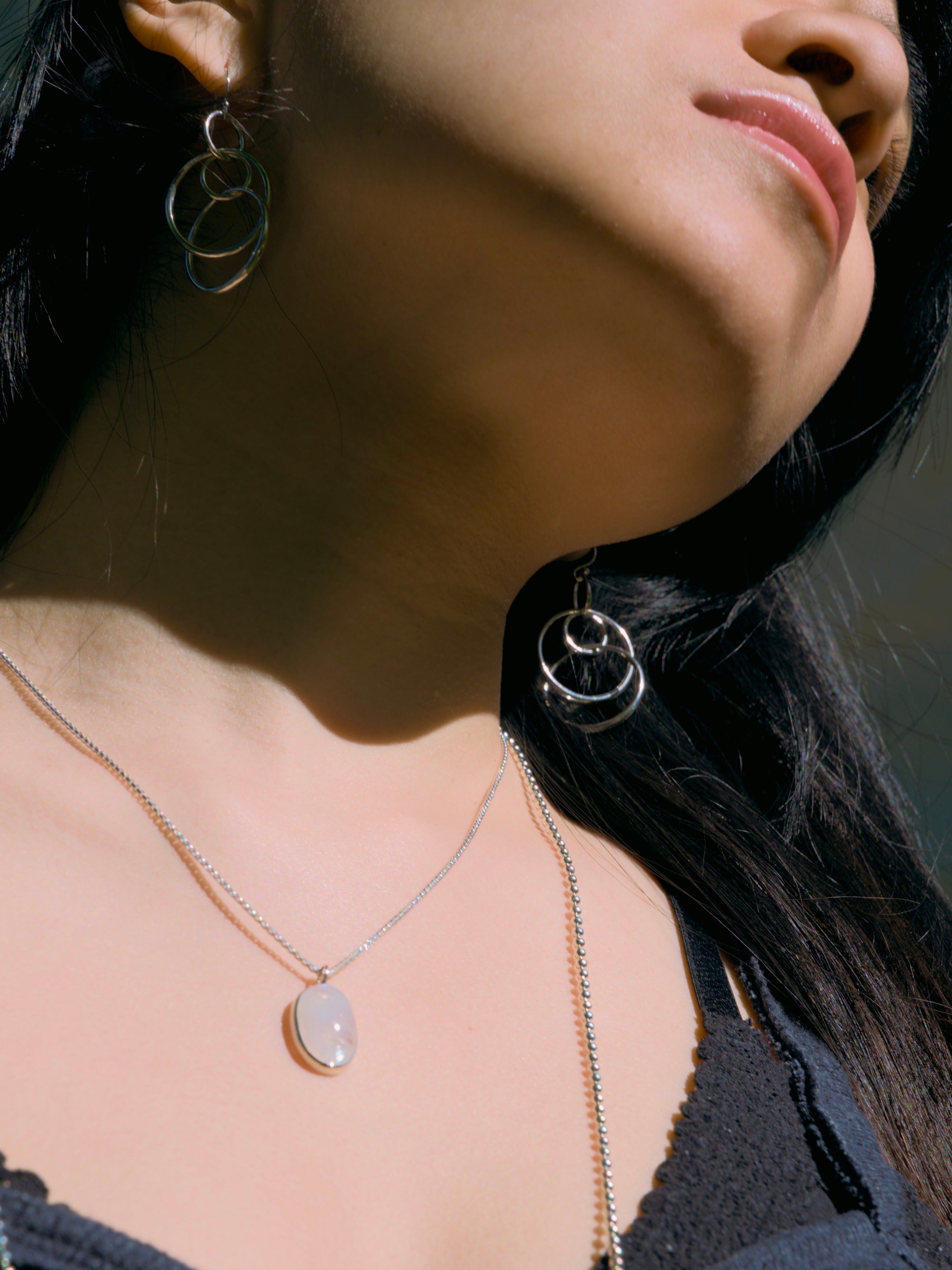 Rainbow Moonstone Oslo Pendant with bead chain layered and Saturn Singles Earrings all by Hannah Daye & Co shown on model