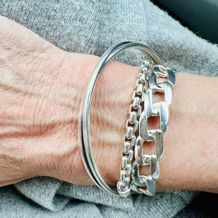 bordillo sterling cuff stacked with bangle and chain bracelets all by hannah daye & co