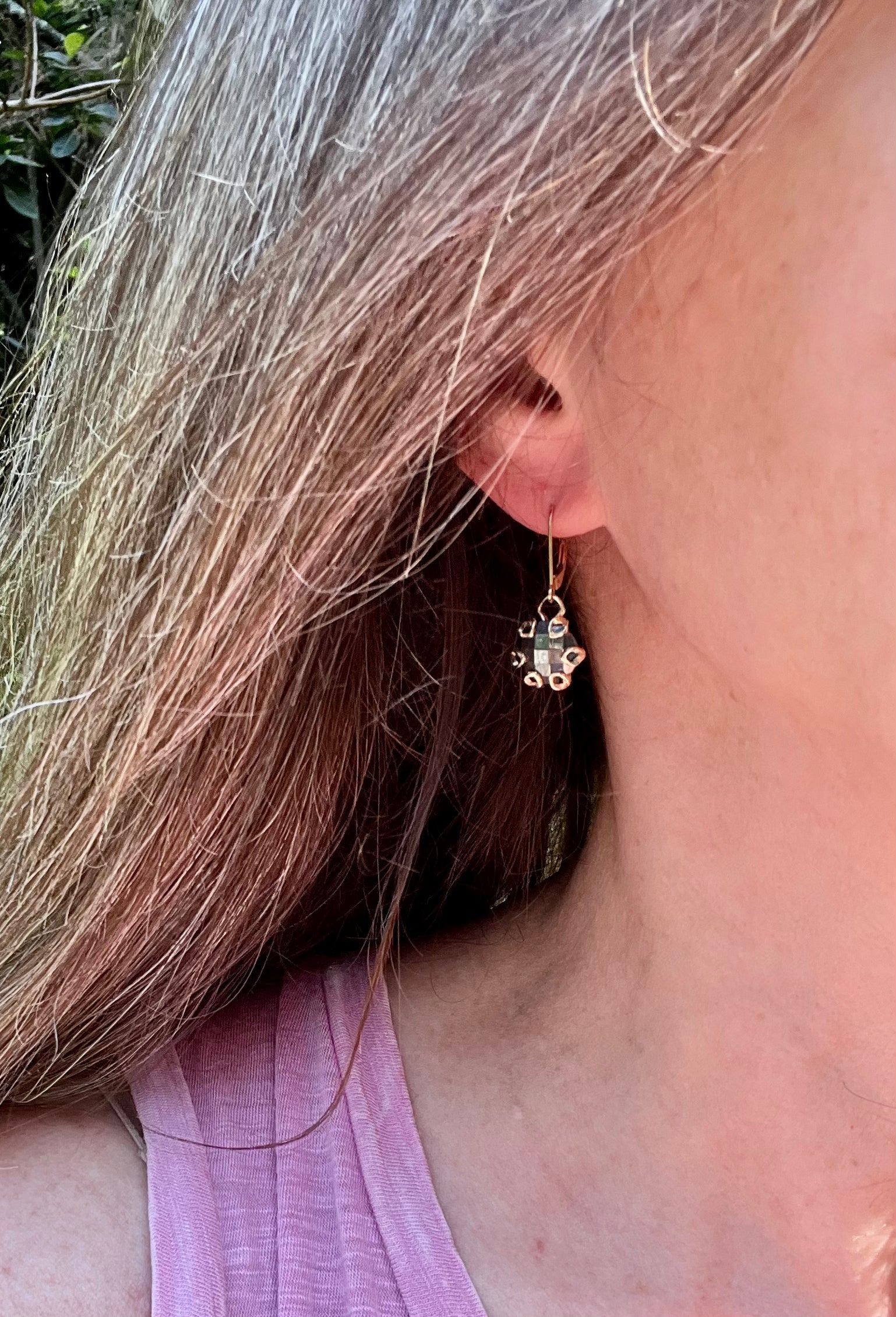 wearing 14k yellow gold poppy drops in hematite by Hannah Daye