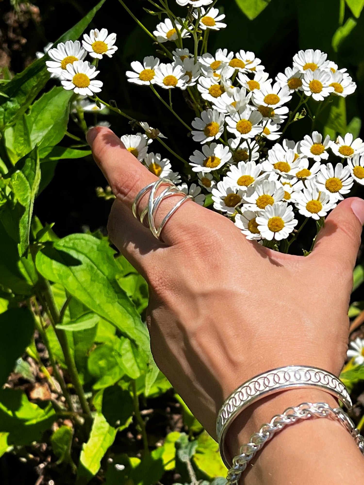 wearing saturn ring along with Oslo Narrow Cuff and Trigo Bracelet all sterling silver all by Hannah Daye & Co