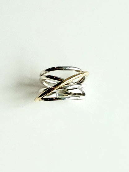 Gold and silver ring on a light gray background