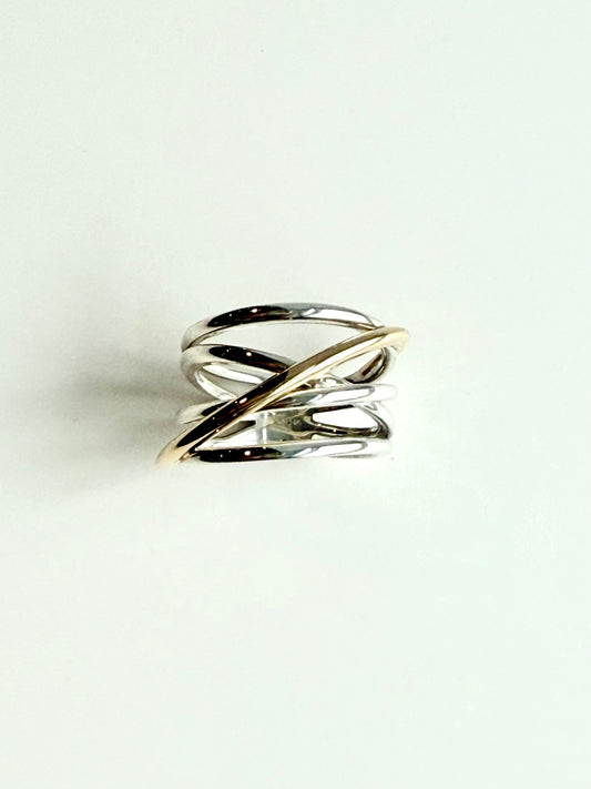 Gold and silver ring on a light gray background