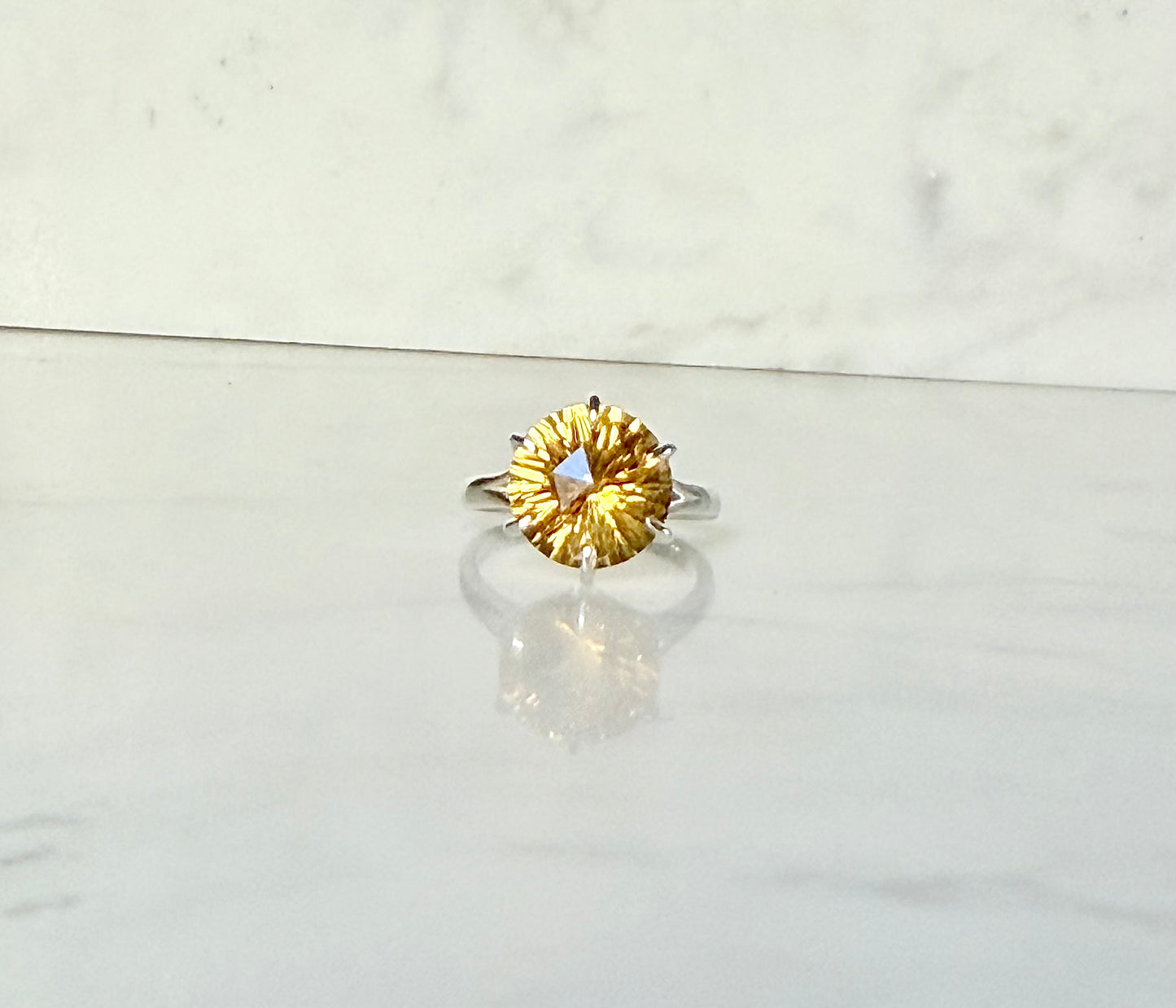 Citrine front view Sterling silver ring by Hannah Daye on smooth stone surface