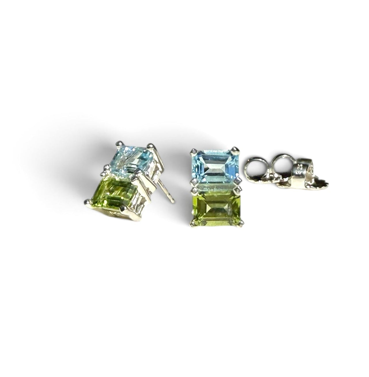 Pair of earrings with green and blue gemstones on a white background