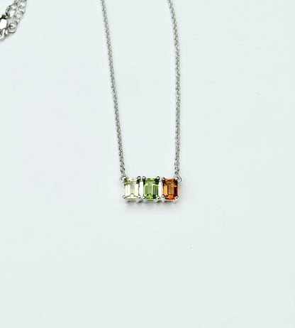 silver necklace with three gemstones green yellow and orange