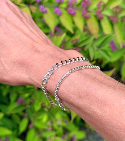 closeup of two silver bracelet