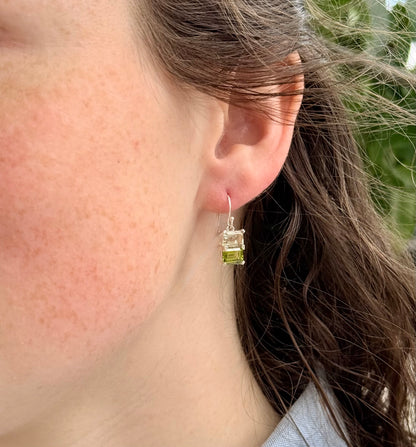Close-up of a person wearing a green gemstone earring.