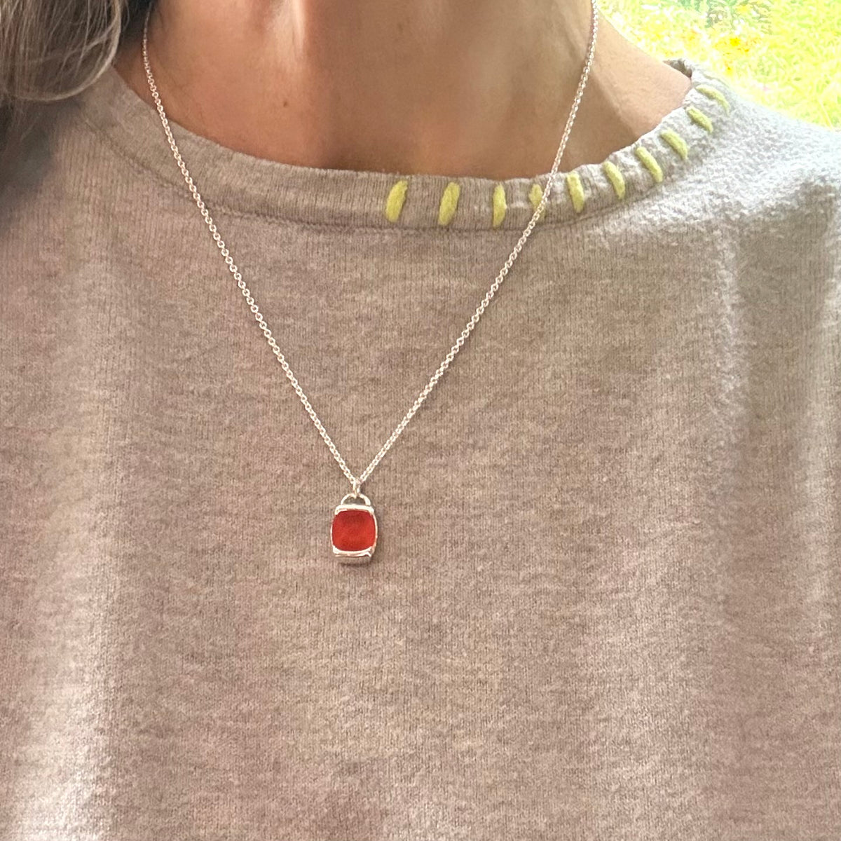 someone wearing red charm pendant