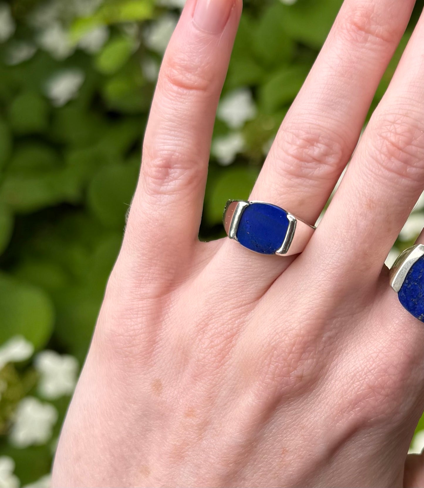 Hand wearing a blue ring
