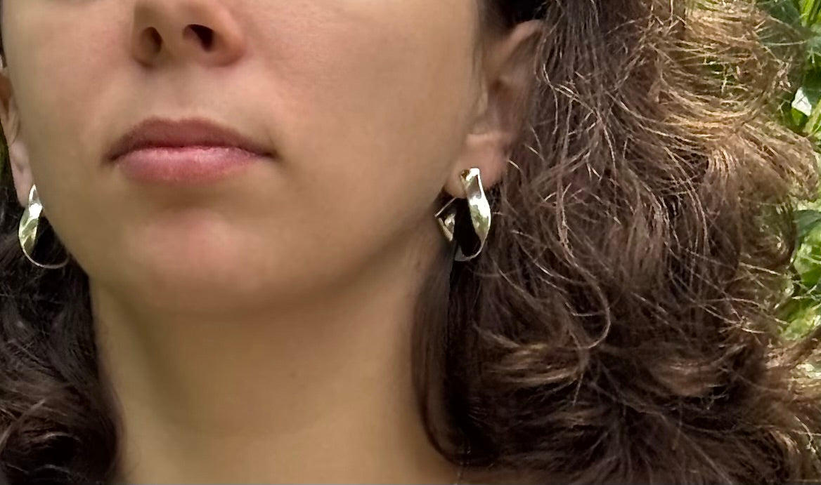 Close-up of a person wearing sterling silver hoop earrings