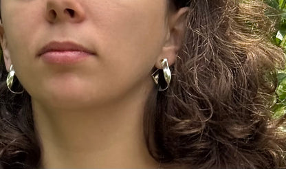 Close-up of a person wearing sterling silver hoop earrings