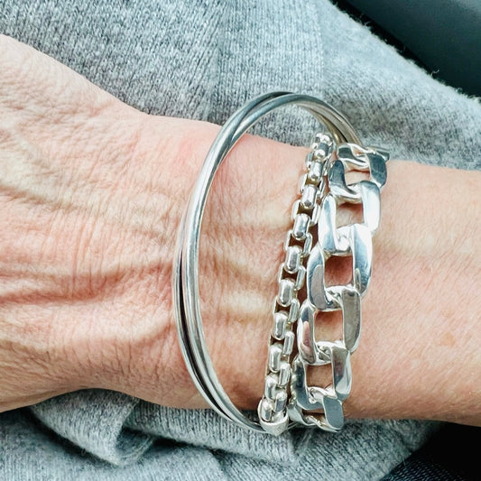 bordillo sterling cuff stacked with bangle and chain bracelets all by hannah daye & co