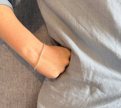Person wearing a silver bracelet 