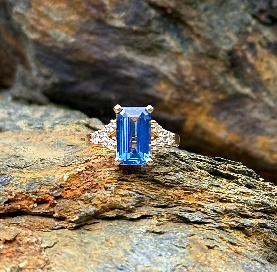 Sapphire and Diamond engagement Ring resting on stone